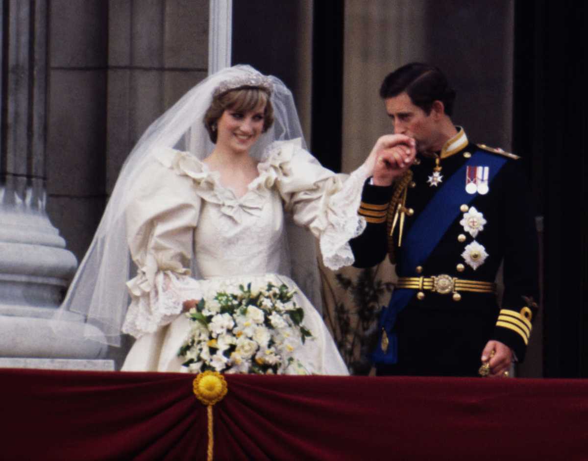 The Prince and Princess of Wales on the balcony of Buckingham Palace on their wedding day, 29th July 1981. Diana wears a wedding dress by David and Elizabeth Emmanuel and the Spencer family tiara. (Image Source: Getty Images | Photo by Terry Fincher)