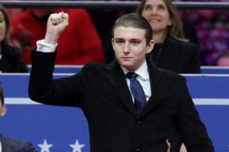Barron Trump with his fist raised up at President Donald Trump's Inaugural Event