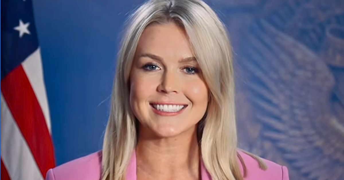Karoline Leavitt smiling in a pink suit while promoting Trump’s “One Big Beautiful Bill” on Instagram.