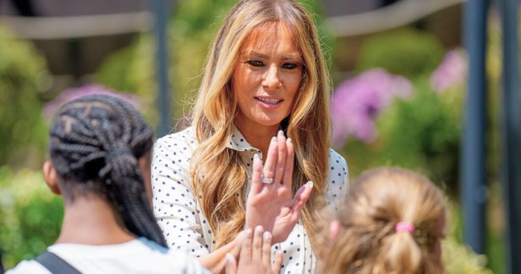 Melania Trump high fiving with children during a hospital visit amid GOP Medicaid cuts
