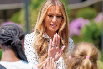 Melania Trump high fiving with children during a hospital visit amid GOP Medicaid cuts