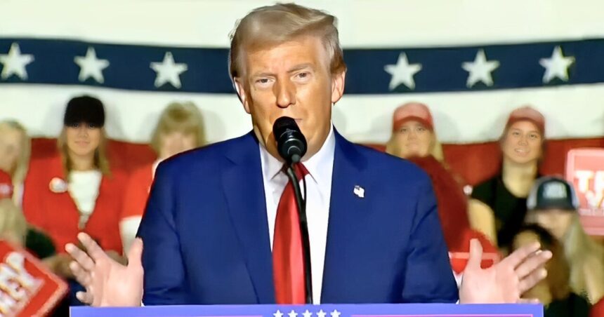 President Donald Trump speaking at a podium with U.S. flags in the background, mid-speech