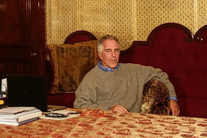 Jeffrey Epstein with files on desk