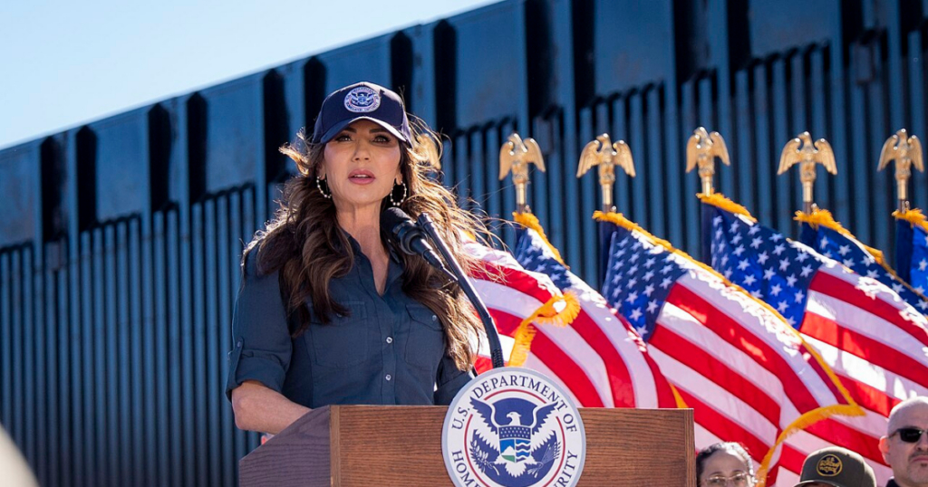 The photo was designed to be pure political theatre. Kristi Noem, hair sprayed into submission, blazer sharp enough to cut glass, sat behind a hefty stack of official papers. A staffer framed the shot just so, ready to capture the precise moment her pen hit the page. Moments later it was on X, the caption landing with all the subtlety of a campaign chant: “Build baby build.” This was meant to be the power image — the 54‑year‑old Homeland Security secretary personally green‑lighting new steel for Donald Trump’s border wall. Instead, it turned into a reminder of a far more awkward truth: the wall that was supposed to be paid for by Mexico is being financed, in black and white, by Americans. Kristi Noem, nicknamed “Ice Barbie” by her critics for her glossy, hyper‑managed image and love of viral stunts — including a notorious flamethrower clip — clearly thought the signing ceremony would signal momentum. DHS had frozen work on roughly 200 miles of planned barriers while it “reviewed” contracts. Her signature, the message went, would break the logjam. The wall was back on. The problem was the fine print. The contract she was so eager to showcase taps into the $46.5 billion that Congress tucked into the sprawling “One Big Beautiful Bill” (OBBB) for border infrastructure and enforcement. There is no foreign contribution. No clever funding wheeze from Mexico City. Just US taxpayers picking up the tab for more steel. That clashes head‑on with the story that helped launch Trump’s political career. On the 2015–16 campaign trail, he was unambiguous: “I would build a great wall… and I will have Mexico pay for that wall.” It was one of the core promises, chanted back at him at rallies, the verbal shorthand for a new, supposedly tougher kind of politics where America would no longer be the mug in every deal. So when Kristi Noem posted her polished “build baby build” moment, social media did what it does best and shredded the illusion in seconds. “I thought Mexico was paying for the wall?” one user wrote, the faux innocence doing more damage than any furious paragraph. Another went straight for the jugular: “Why would we purchase steel? Don said that Mexico was paying for it… what changed?” The “Ice Barbie” nickname resurfaced, not just as a personal dig but as a critique of the whole performance. “Performative… Mexico didn’t pay for the thing that Trump promised Mexico would pay for,” one commenter noted, encapsulating the sense that Noem’s pen was doing less governing than brand management. Strip away the snark, and there is a hard political fact underneath: by signing that contract, Kristi Noem effectively acknowledged that the central, crowd‑pleasing promise of the wall project has collapsed. The barrier is still being built. Mexico is not paying for it. Americans are. To be fair, Donald Trump and his team have been trying to rewrite this story for a while. By 2023, faced with awkward questions about funding, the former president had shifted into full revision mode. Critics, he said, were “losers” who didn’t understand that he had only pledged Mexico would pay for “a piece” of the wall. Then came the quiet admission: “Well, there was no legal instrument to do that.” That is a long way from the swaggering 2015 boast that “nobody builds walls better than me” and that Mexico would foot the bill. It’s also a glimpse of how the fantasy functioned: useful on stage, impossible on paper. While Trump worked the rally circuit, lawyers and appropriations committees in Washington quietly did the grown‑up job of finding domestic money. On Capitol Hill, the reality is straightforward. Congress — not President Andrés Manuel López Obrador — wrote border wall funding into OBBB. Hard‑right allies such as Arizona congressman Andy Biggs have bragged about helping to secure the cash and ensuring construction would be completed. For the MAGA base, the distinction between cheering the wall and paying for it may blur. For everyone else with a tax bill, it is much starker. That is why Kristi Noem’s little photo‑op stung. She wasn’t just signing off on a steel order; she was signing a line item that proves the United States is repeatedly absorbing the cost of a project repeatedly sold as free. The timing is not great for her personally either. Once touted as a breakout star in Trumpworld, Kristi Noem's stock has slipped. After two fatal ICE shootings in Minneapolis, she was reportedly stripped of responsibility for interior immigration enforcement. Oversight of that turf was handed to Donald Trump's favorite and self‑styled “border czar” Tom Homan — a man the president says he “knows and likes,' which in this ecosystem is more important than any organisational chart. Kristi Noem was told to focus solely on the southern border, a move that looked a lot like a demotion in all but name. Against that backdrop, the steel‑signing photo reads like an attempted comeback: look, I’m still central to the mission, still the one literally building the wall. The irony is brutal. In trying to prove her loyalty and relevance, she ended up highlighting the administration’s most glaring IOU. The “Ice Barbie” jibe may be petty, but the underlying charge is not: voters are being asked to forget the distance between the campaign fantasy — a magnificent barrier conjured on someone else’s dime — and the dull reality of multi‑billion‑dollar appropriations and domestic procurement. Forty‑six and a half billion dollars is not political pocket change. It is money that could be spent on roads, on schools, on hospitals. To wave it away with a glib “build baby build” while retro‑fitting the original pledge into something it never was is, frankly, an insult to anyone who has been paying attention. From the outside, it all feels grimly familiar. Grand slogans about borders and control have a habit of smashing into the brick wall of legal and fiscal reality. When they do, politicians often reach not for honesty but for better lighting and a sharper photo. Kristi Noem's pen stroke was supposed to project strength and progress. Instead, it captured the precise moment a campaign myth finally collided with the invoice. The steel will be bought, the fence posts will rise, and the bills will land — not in Mexico City, but in American mailboxes. The only real unknown now is whether the people who once chanted “Mexico will pay” care enough to notice that, in the end, it was always going to be them.