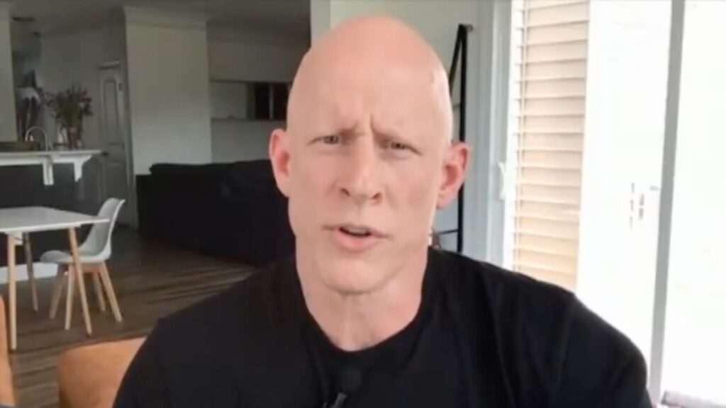 Brian McGinnis reveals the surgical scars after he broke his arm during a senate protest.