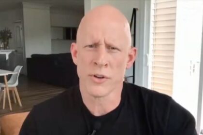 Brian McGinnis reveals the surgical scars after he broke his arm during a senate protest.