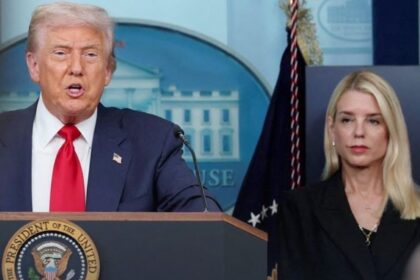 a picture of Pam Bondi standing beside donald trump during a speech in Washington