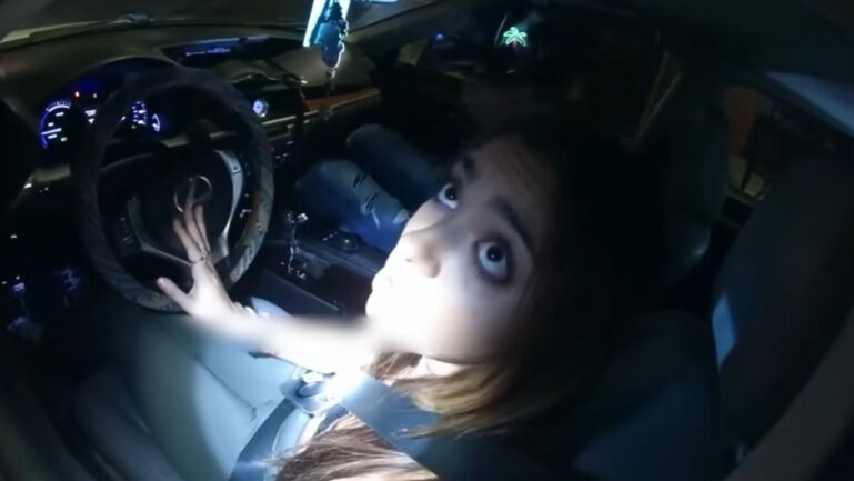 Ohio Driver in a seatbelt looks up inside a car at night, hand on wheel