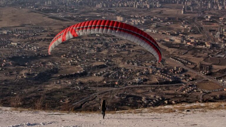 Police arrested a man who performed a parachute stunt from a residential building.